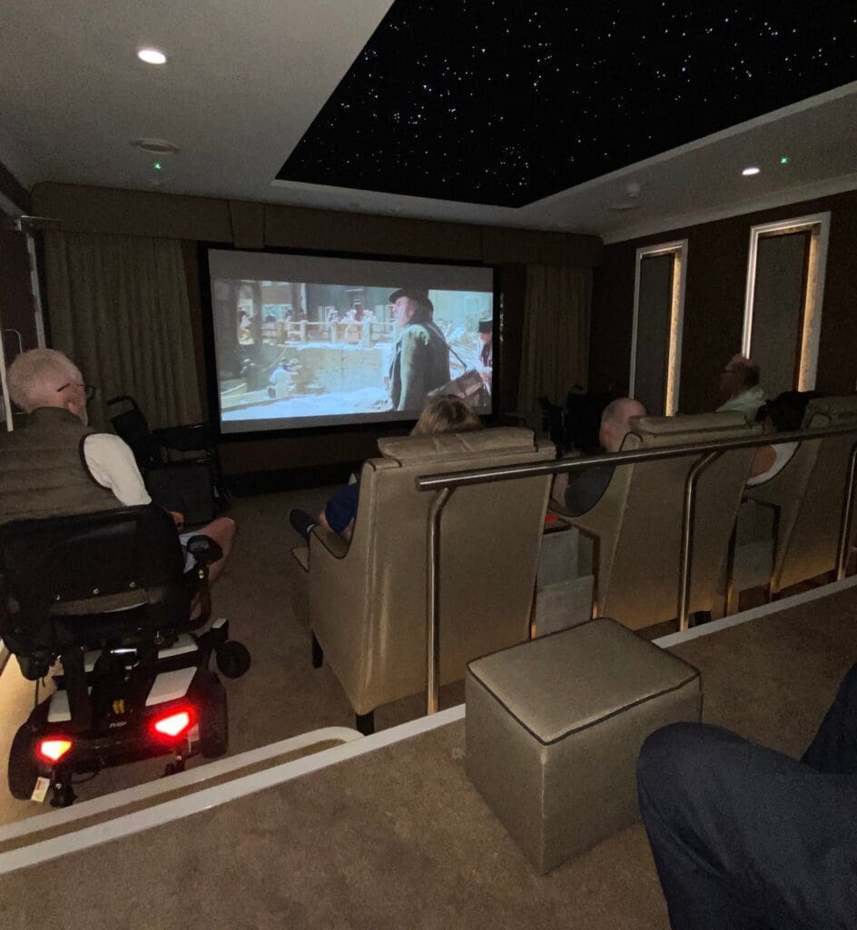 Our residents with members of the Stroke Association watching a film in the Cavell Park care home cinema room.