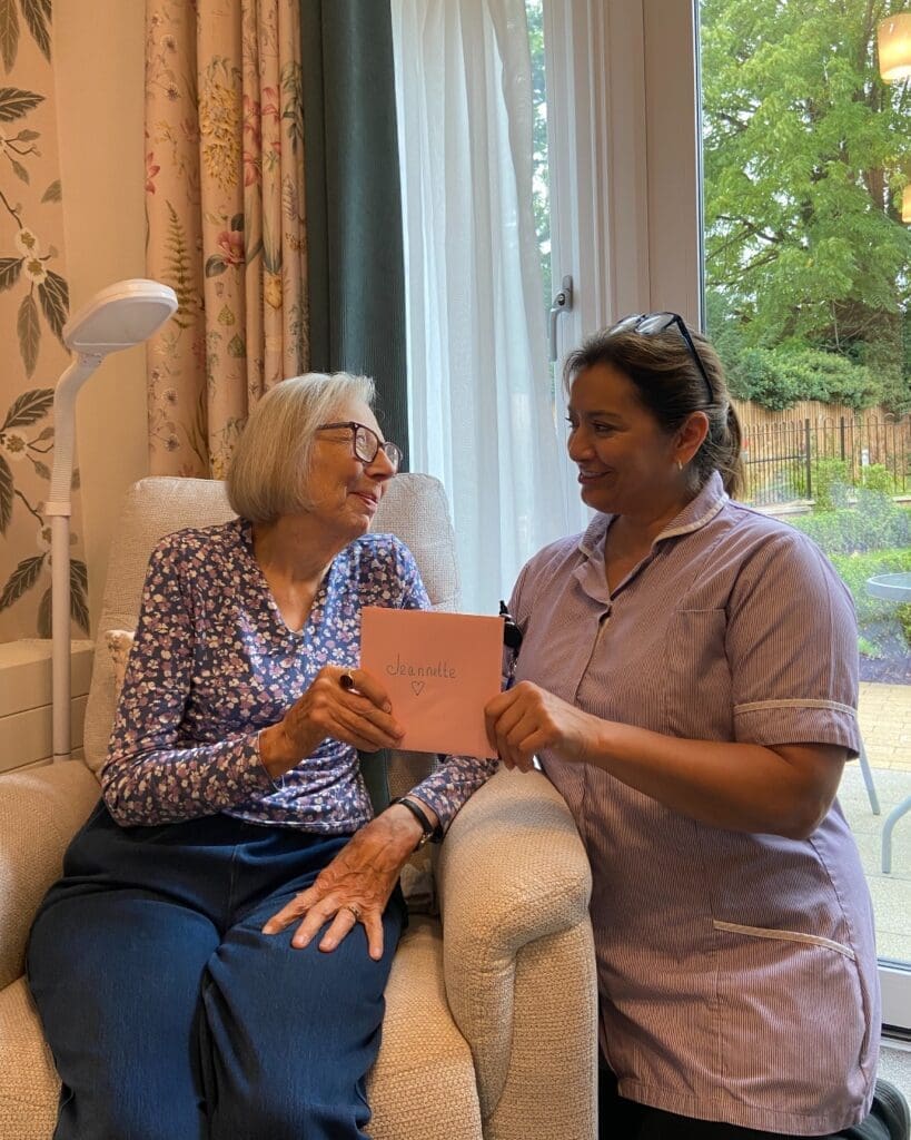 One of our residents at Barley Manor care home giving a handmade thank you card to one of our team members.